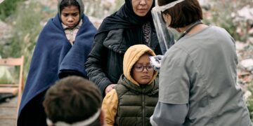 Checking Temperature Of Refugee Child