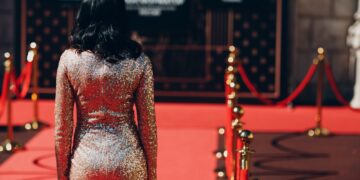 Woman in a luxurious dress on a red carpet.